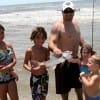 The West family of Liberty gather around dad who just landed this nice gaftop catfish from the surf.
