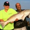 Ray Sockwell helps Sandra Beard of Deer Park,TX hold her 41inch tagger bull red she caught on finger mullet.