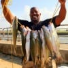 Veron Brealing of Houston hefts a heavy stringer of trout he and his brother caught from the surf on mirror lures.