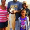 A Proud Humphrey family hovers around Daddy Eric with his 40 inch tagger bull red he caught on a finger mullet