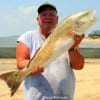 Wayne Caraway of Spurger TX hefts this 35 inch tagger bull red that was caught on shad