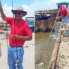 Jessie Garcia of McKinney TX caught this 27inch slot Red while fishing a soft plastic lure; fellow angler helping Jessie land his fish