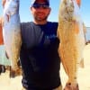 Ricky Newton of Crystal Beach TX hefts this trout and red caught on finger mullet