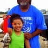 Grandpa Wallace Moore of Mo-City TX helps granddaughter Caylyn Lacy with her first fish-- released