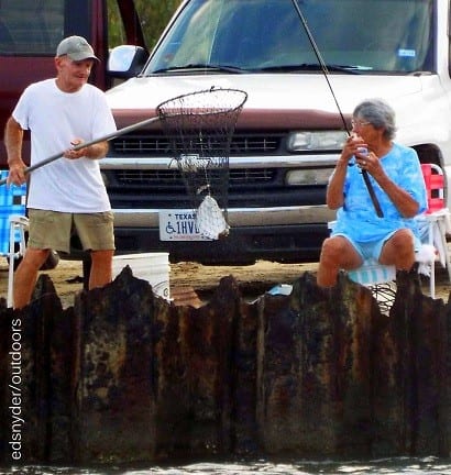 Barbara Singleton of Winnie TX is helped by her hubby on netting this nice flounder she caught on finger mullet