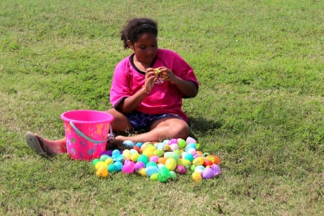 The happy hunters plopped down in the grass to open the eggs and find the candy surprise inside.