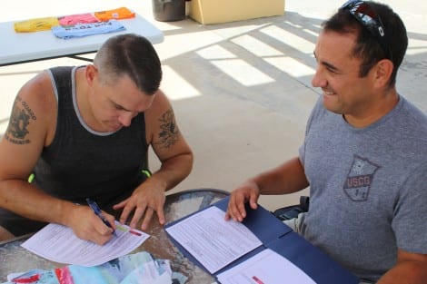 Corey Weber signing US Coast Guard re-enlistment paperwork at Fun Town in Crystal Beach